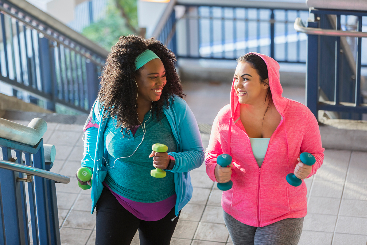 Two women jogging together and smiling after getting Charcot joint treatment in San Francisco.